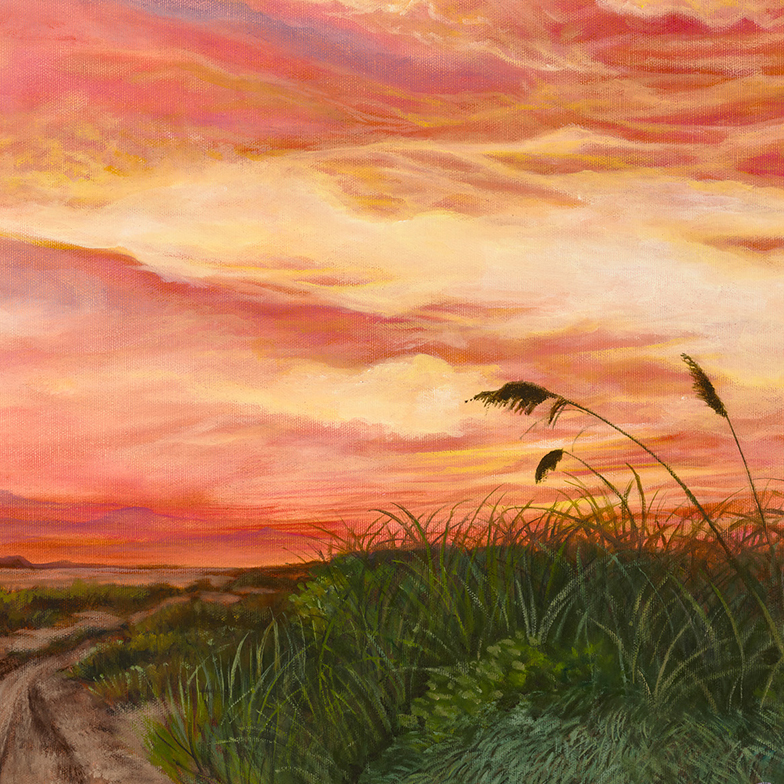 Sand dunes with grass and vegetation with a blue bus with a person sitting facing a pink and yellow sunset